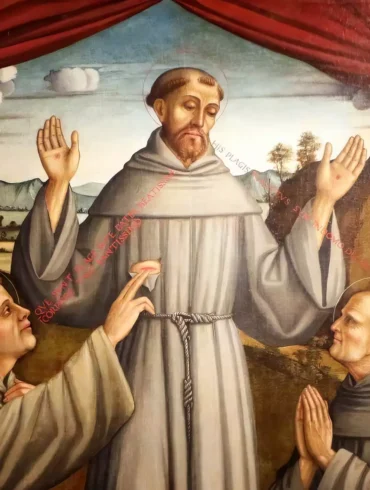 Detail of Saint Francis with raised hands from Sacred Representation with Saints Francis, Anthony and Bernardino by Pietro Paolo Agabiti (1530), showing the central figure against a blue sky with red curtains 7