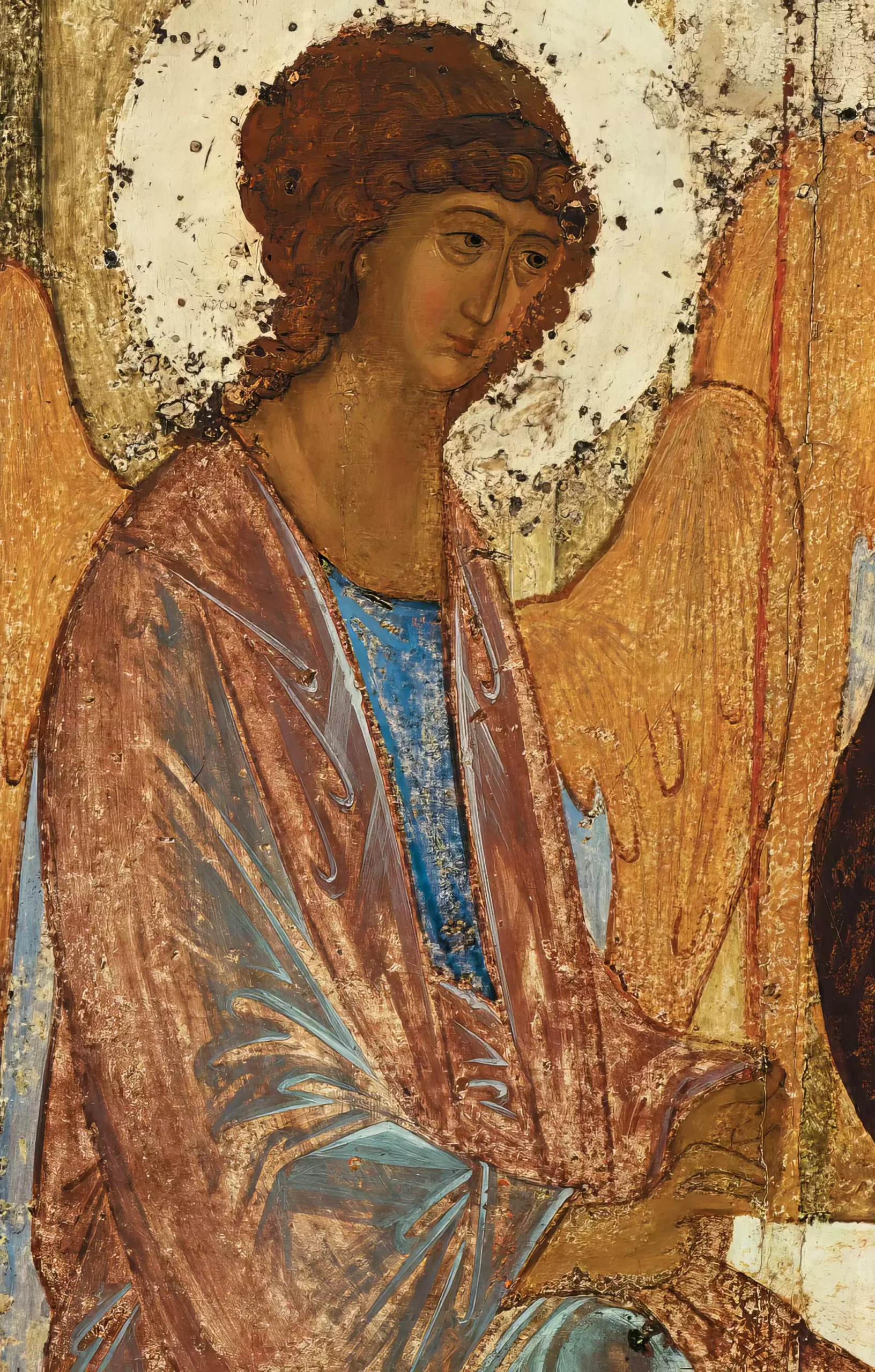 Close-up detail from Andrei Rublev's Trinity Icon (1425-1427), focusing on the left angel's contemplative face, distinctive curls, and harmonious blend of brown and azure robes set against the gilded background 7