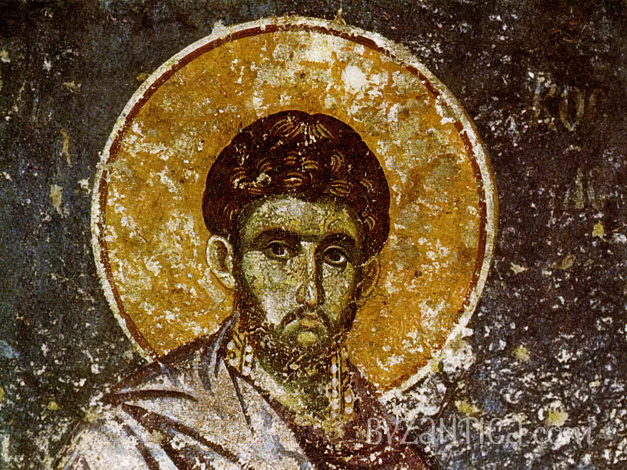 Detail of Saint Cosmas in Protaton byzantine fresco showing the saint's face and golden halo