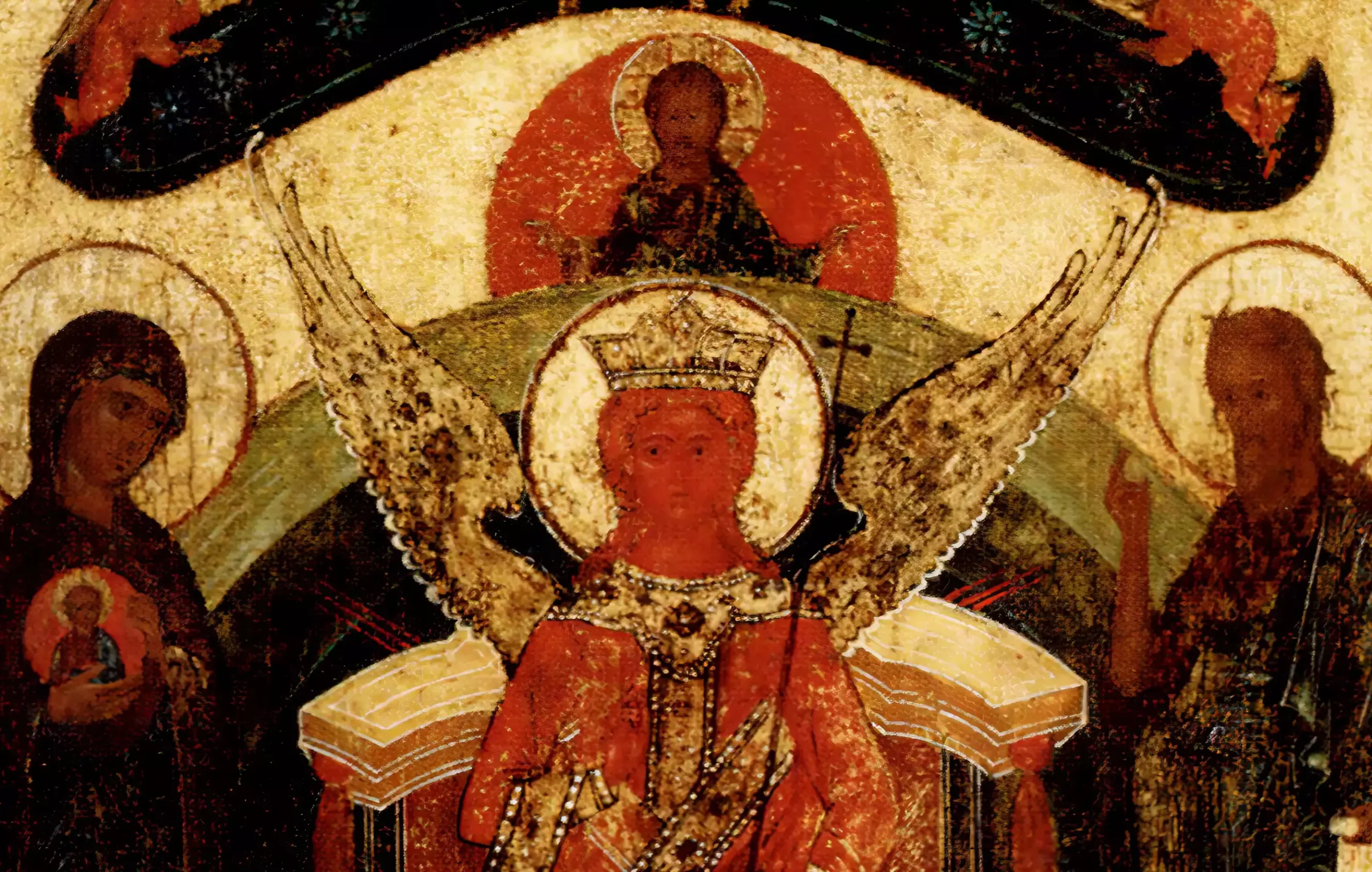 A detail from the 15th century icon depicting Christ blessing in a red mandorla with seraphim angels in a dark arc, accented with gold leaf highlights